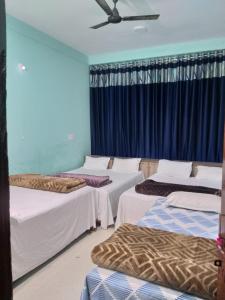 JāmbにあるShree DashbhujaNath Staysのベッド4台と天井ファンが備わる客室です。 +7枚の写真