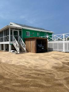 a green building with a large patio in front of it at Byron's Belize Dream in San Pedro