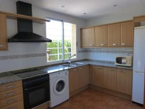a kitchen with a washing machine and a sink at Adosado Calle Mar Cantabrico in Puebla de Vallbona