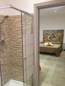 a bathroom with a shower with a bed in the background at Casa Vacanza Marijò in Sant'Isidoro +56 photos