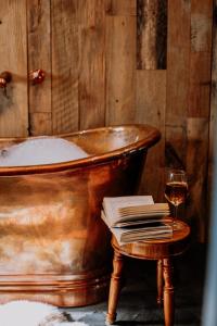 an old tub with a book and a glass of wine at Slowley Farm in Luxborough