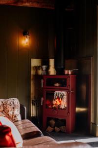 a red stove with a fire in a room at Slowley Farm in Luxborough +77 photos