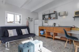 a kitchen and living room with a couch and a desk at Villa Luna Wifi Fibra in Lajares