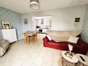 a living room with a red couch and a kitchen at Les Iles d'ici in Rochefort +18 photos