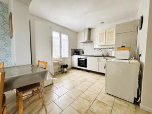a kitchen with a refrigerator and a table in it at Les Iles d'ici in Rochefort +14 photos