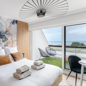 a bedroom with a bed with towels on it at Horizon bleu depuis un studio unique in Carnac