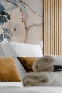 a bed with pillows and a painting on a wall at Horizon bleu depuis un studio unique in Carnac