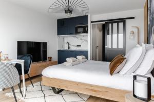 a bedroom with a bed and a desk and a tv at Horizon bleu depuis un studio unique in Carnac