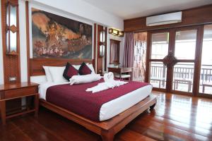 a bedroom with a bed with two white towels on it at Chanthapanya Hotel in Vientiane