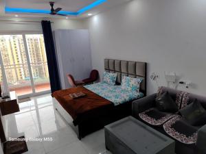 a bedroom with a bed and a couch at Hello Studio in Noida