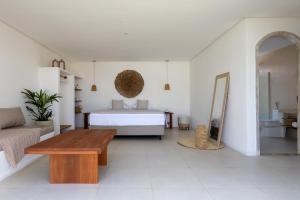 Un dormitorio blanco con una cama y una mesa. en Vila Nazare, en São Miguel do Gostoso