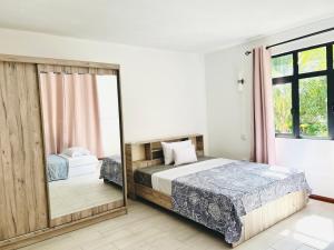 Un dormitorio con dos camas y un espejo. en Sea View Apartment, en La Gaulette