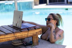 サンティアゴにあるラ カサ ロハ ホステルのテーブルの前にノートパソコンを置いて横たわる女性