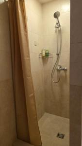 a shower with a shower curtain in a bathroom at Vytauto Apartments in Šiauliai