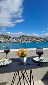 a table with two chairs and a view of the water at Sarandë TopView Apartment Portside in Sarandë