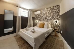 a bedroom with a large bed with white sheets at Casa Lamy in Aldeia Galega da Merceana