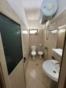 a bathroom with a toilet and a sink at Hotel Kudhesi in Vlorë
