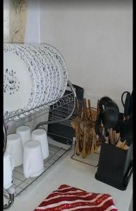 a shelf with dishes and other kitchen utensils at Lynn in Nanyuki