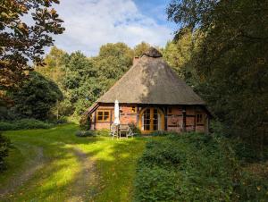 a small wooden house with a thatched roof at Hus in Huddel - Worpswede - Teufelsmoor in Osterholz-Scharmbeck