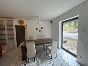 a dining room with a table and chairs and a window at Wohlfühloase Hennef in Dambroich