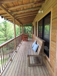 une terrasse couverte en bois avec un banc sur une maison dans l'établissement Cabaña El Sol, à Rionegro