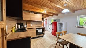a kitchen with a table and a red refrigerator at Schilchernhof - Ferienwohnungen im Allgäu in Dietmannsried