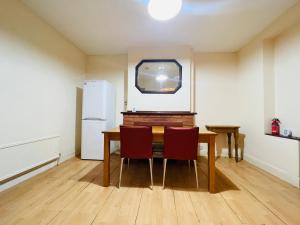 a dining room with a table and a refrigerator at Budget Stay In Luton 02 05 in Luton +6 photos