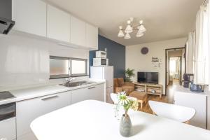 a kitchen and living room with white cabinets and a table at Nogata Station 3 minutes on foot , 15 minutes to Shinjuku in Tokyo