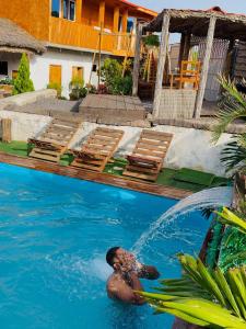 a man in a swimming pool with a fountain at Quinta Refúgio in Ribeirão Chiqueiro