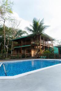 a resort with a swimming pool in front of a building at Pousada Bellissima in Boicucanga