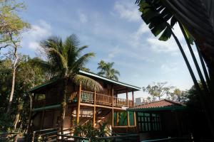 a house with a palm tree in front of it at Pousada Bellissima in Boicucanga
