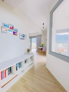 a white room with a large window and a book shelf at Comfy Vista Apartment in Kalamata