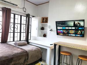 a bedroom with a bed and a desk and a tv at Apartment near Malls in General Santos