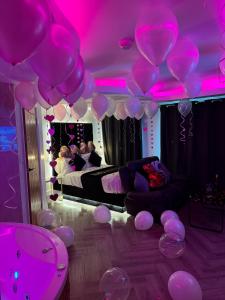 a room filled with pink balloons and a bed at Mansa Apartments in Bradford
