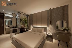 a bedroom with a bed and a vanity and a mirror at Cubicity Pho Duc Chinh in Ho Chi Minh City