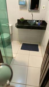 Un baño con lavabo, inodoro y espejo. en Hostel da Dinda, en São Luís