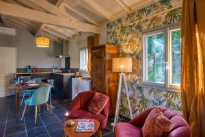 a living room with chairs and a table and a kitchen at spa privatif intérieur du lodge -la truffe- le bois de la pause- in Saint-Cybranet