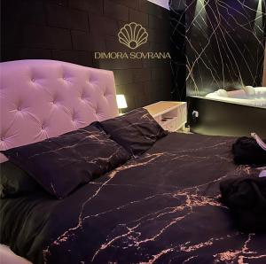 un letto con testata viola in una stanza di Dimora Sovrana - Deluxe Suite Matera a Matera