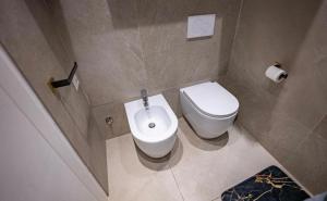 un bagno con un water bianco e un lavandino di Dimora Sovrana - Deluxe Suite Matera a Matera