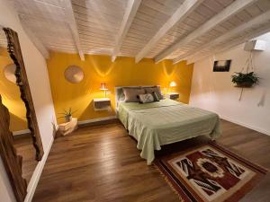 a bedroom with a bed and yellow walls at Casa Eliana appartamento Sole in Meina