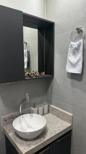a bathroom with a white sink and a mirror at Flat Novissimo ,100M mar , praia Intermares, acomoda ate 4 pessoas in Cabedelo