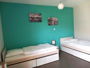 GuéreinsにあるLes Gites de la Calonneの青い壁の部屋にベッドが2つある