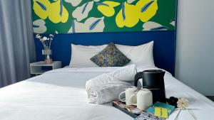 a bedroom with a white bed with a blue headboard at Traveller Ark Hotel and Bunks in Kuala Lumpur