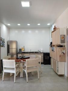 a kitchen with a table and chairs and a refrigerator at Refúgio encanto das montanhas in Nova Friburgo