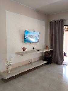 a living room with a tv on the wall at Refúgio encanto das montanhas in Nova Friburgo +11 photos