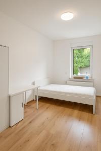 a white room with a bed and a window at City Apartments in Osnabrück in Osnabrück
