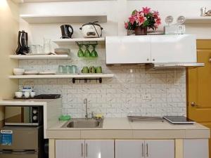 a kitchen with white cabinets and a sink at DaLei 3- 103 Sleeps 8pax at Marina Spatial Condominium in Dumaguete City in Dumaguete