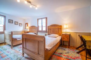a bedroom with two beds and a desk in it at Typical Alsace house - ideal for groups and families in Dambach-la-Ville