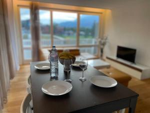 una mesa con platos y vasos y una botella de agua en Modernes Luxus Apartment direkt neben Shopping und Bus, en Schaan