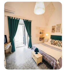 a bedroom with a large bed with green curtains at Casa Agrumeto 28 in Ostuni